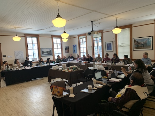 25 people sitting at tables in the shape of a U