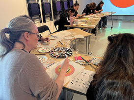 people sitting at tables painting