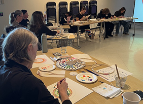 people sitting at tables painting