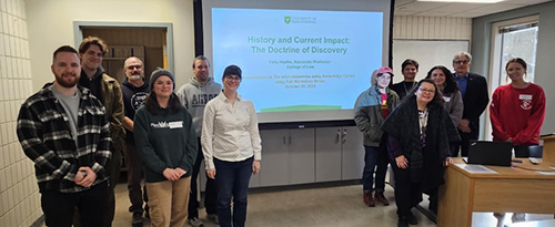 group of people standing near projector screen