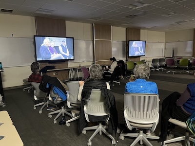 dark room with a group of people watching a tv screen