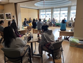 group of people sitting in chairs in a circle 