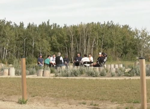 group of people sitting outside in a circle